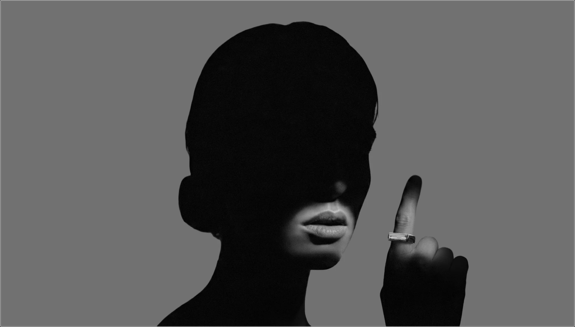 Black-and-white silhouette wearing the Murmur ring on a pointed finger