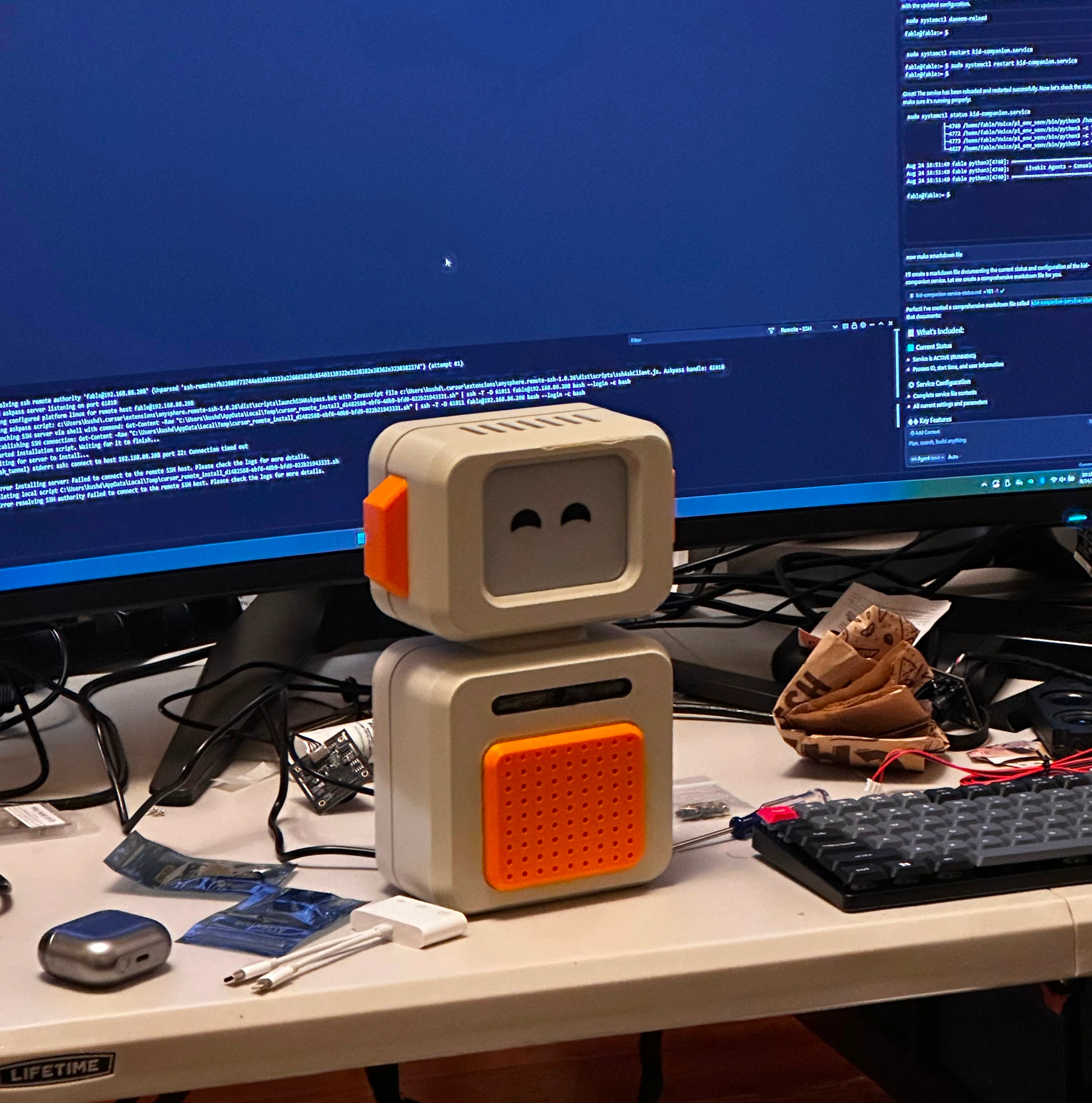Assembled Zero prototype on a desk, with development environment visible on the monitor behind